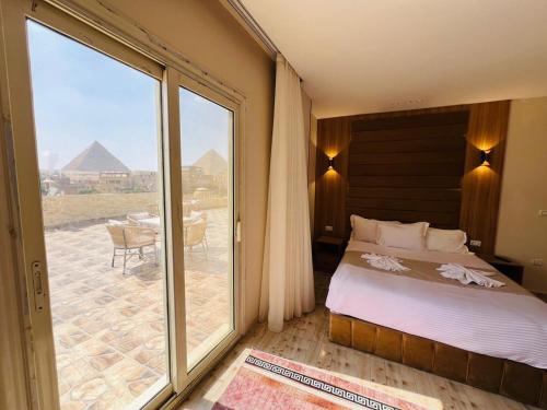 a bedroom with a bed and a view of the pyramids at House Pyramids View Hotel in Cairo