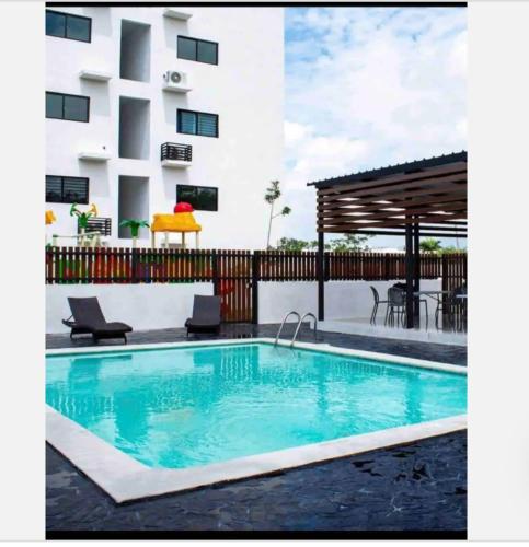 a swimming pool in front of a building at Torre con ascensor y vigilancia in Santiago de los Caballeros