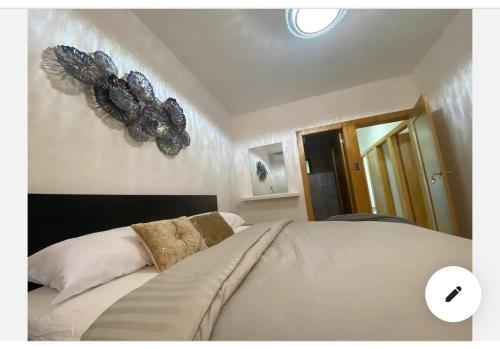 a bedroom with a large white bed with a butterfly on the wall at Torre con ascensor y vigilancia in Santiago de los Caballeros