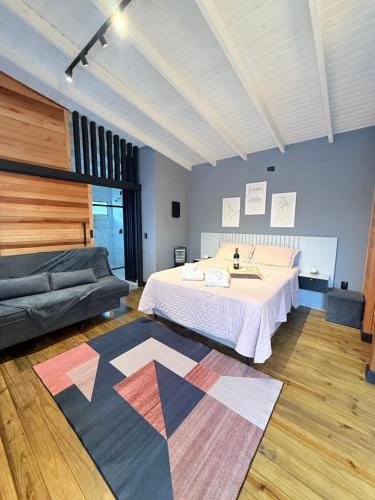 a bedroom with a bed and a couch at Cabana do Lago com passeios a cavalo gratuito in Urubici