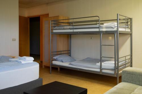 two bunk beds in a room with a couch at FarNorth Hostel in Bakkafjörður