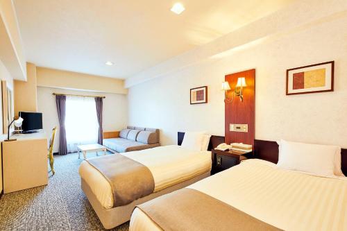 a hotel room with two beds and a couch at Nara Royal Hotel in Nara