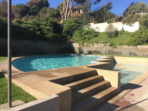 een zwembad met trappen in een tuin bij Solvallerios Apartments in Viña del Mar