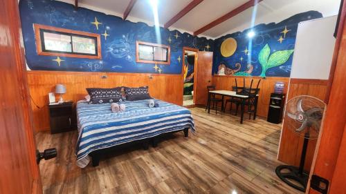a bedroom with a bed with a blue wall at HARE O HAUPIANO in Hanga Roa