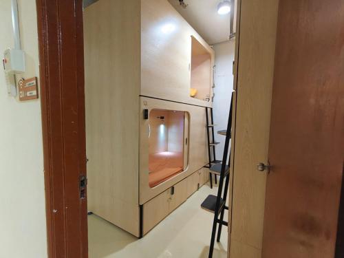 a small room with a sink and a door at Sleepy Bear Capsule Hostel in Johor Bahru
