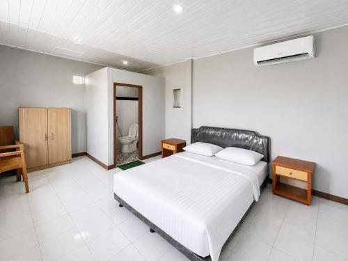 a bedroom with a bed and a bathroom with a toilet at Nata Hotel Tasikmalaya in Gunungcupu