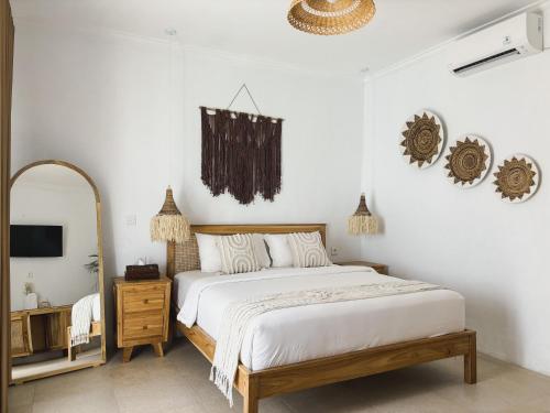 a bedroom with a large bed and a mirror at La PAYANA House Penida in Nusa Penida