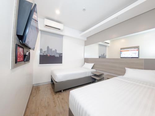 a hotel room with two beds and a flat screen tv at Red Planet BGC The Fort in Manila