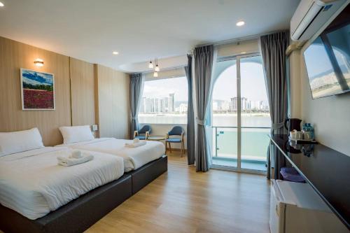 a hotel room with two beds and a large window at โรงแรมดีวิว โกลเด้นไทรแองเกิ้ล เชียงแสน - Dview Golden Triangle Hotel Chiangsaen in Golden Triangle