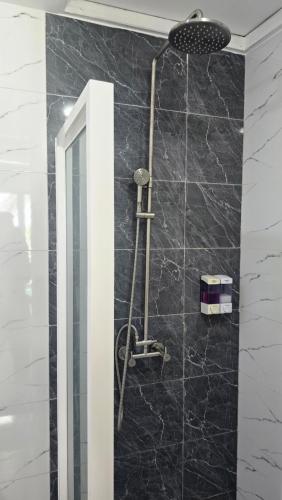 a shower in a bathroom with a black marble wall at The Pearl Seaview in Fulidhoo