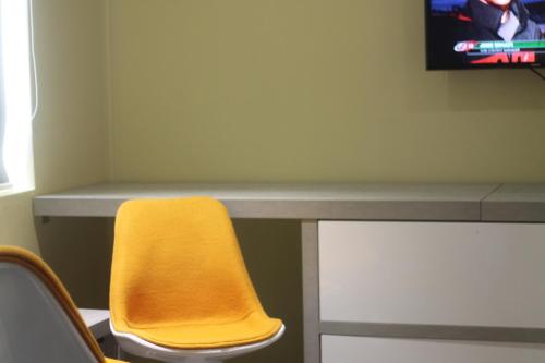 a yellow chair sitting in front of a desk at Benny's City Hotel in Sihanoukville