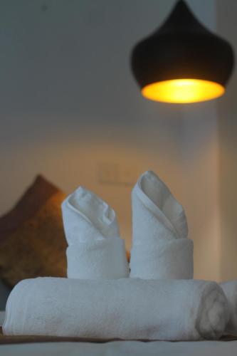 a pair of white socks sitting on top of a bed at Benny's City Hotel in Sihanoukville