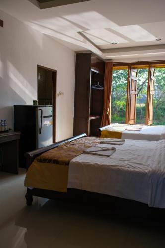 a bedroom with a large bed and a kitchen at Romantic Vang Vieng resort in Vang Vieng