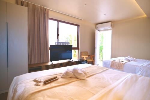 a hotel room with two beds and a window at KHAMI HOUSE Resort in Panglao Island