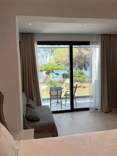 a bedroom with a bed and a view of a patio at Captains Studios & Apartments in Kavos