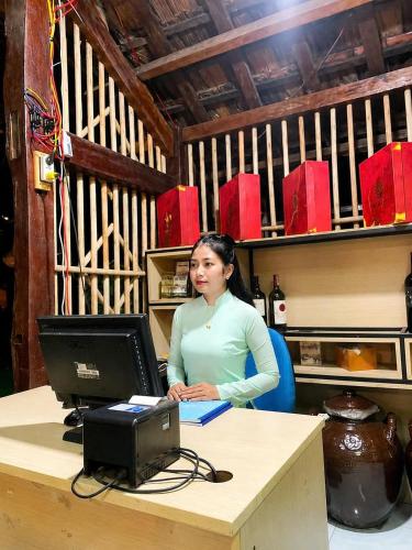 a woman sitting at a desk with a computer at Dak Nguyen Homestay DakLak in Buon Ma Thuot