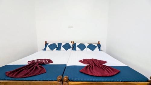 a bedroom with a bed with red robes on it at Thuru Sisila Resort in Anuradhapura