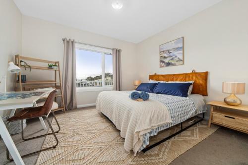 a bedroom with a bed and a desk and a window at San Remo Bay Views Phillip Island Gateway in San Remo