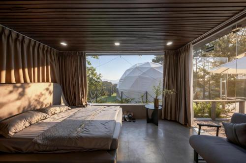 a bedroom with a bed and a large window at Chanchill Glamping&cafe in Xuân Thọ