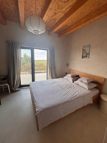 a bedroom with a large bed and a large window at Casa Zaan in Sulina