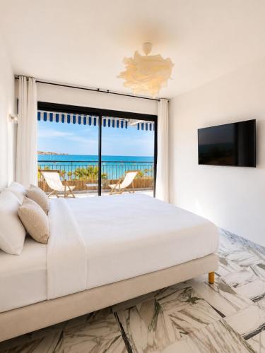 a bedroom with a large bed and a view of the ocean at Bandol Appartement Luxe vue mer époustouflante en face des plages in Bandol