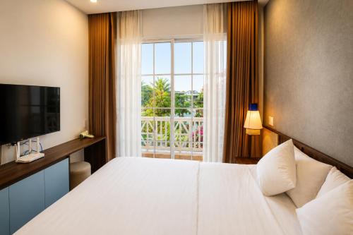 a hotel room with a bed and a window at Modern 3BR Villa , Poolside, 4min Shuttle to Beach in Bình Tú
