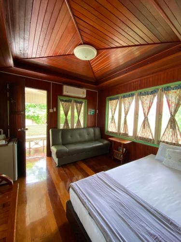 a bedroom with a bed and a couch and windows at Baan Suan Yensabai @Ayutthaya in Phra Nakhon Si Ayutthaya