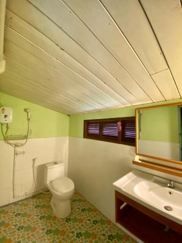 a bathroom with a toilet and a sink and a mirror at Baan Suan Yensabai @Ayutthaya in Phra Nakhon Si Ayutthaya