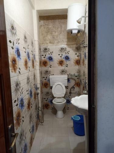 a bathroom with a toilet and a sink at Vibgyor Hotel in Cherrapunji