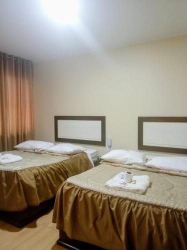 a hotel room with two beds with towels on them at Perú Andina Tours & Hostel Amparo in Huaraz