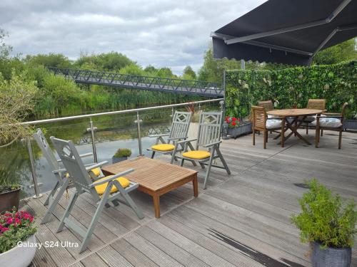 a deck with chairs and a table and a table and chairs at The Floating Home at Upton in Upton upon Severn