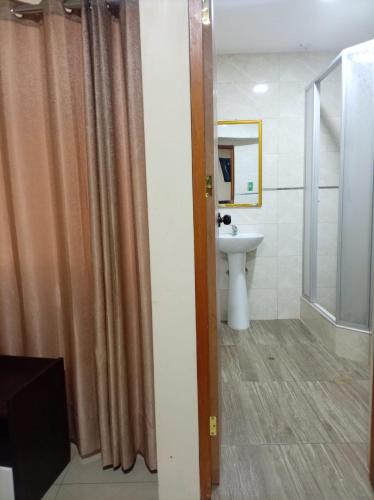 a bathroom with a shower curtain and a sink at Perú Andina Tours & Hostel Amparo in Huaraz