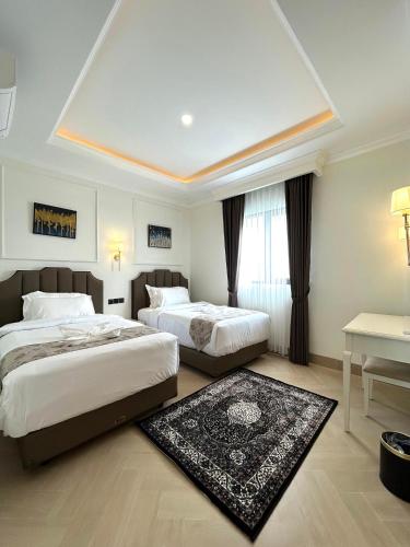 a hotel room with two beds and a table at Royal Classic Puncak in Cisarua