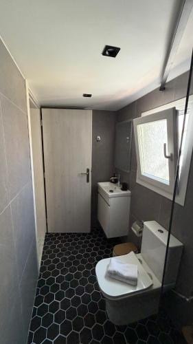 a small bathroom with a toilet and a window at Secret-Garden in Chios
