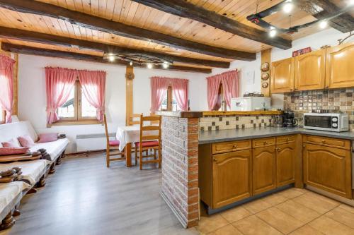 a kitchen with wooden cabinets and a living room at Rustic Cottage With Heated Pool - Happy Rentals in Velika Buna