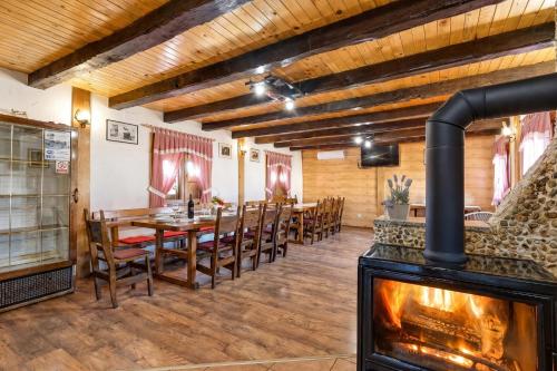 a dining room with a fireplace and a table and chairs at Rustic Cottage With Heated Pool - Happy Rentals in Velika Buna