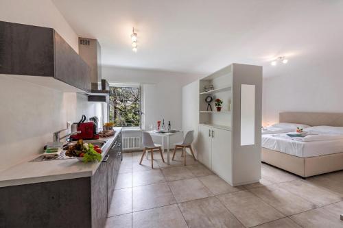 a kitchen and a bedroom with a bed and a table at Residenza La Serenata in Cavigliano