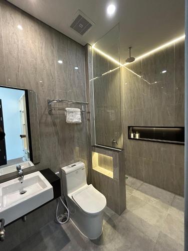 a bathroom with a toilet and a sink and a mirror at Royal Classic Puncak in Cisarua
