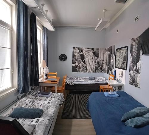 a room with two beds and a room with two tables at Hostelli Marja in Mikkeli
