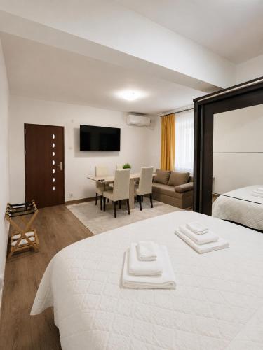 a bedroom with a large bed and a living room at Studio Veronica - Ultracentral, langa Tomis Mall, Self Check-in, Free Parking, Fast WiFi, 10 min Plaja Modern in Constanţa