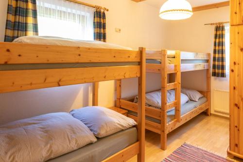 two bunk beds in a room with a ladder at Haus Obweg - Postalm in Abtenau