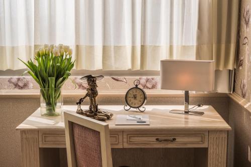 - un bureau avec une lampe et un vase de fleurs dans l'établissement Suites Perisur Apartamentos Amueblados, à Mexico