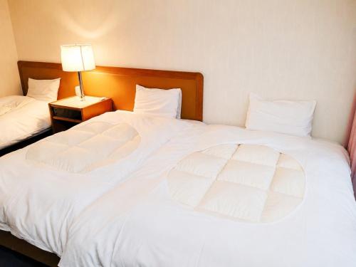 two large white beds in a hotel room at Minami Hakone Villa in Kannami