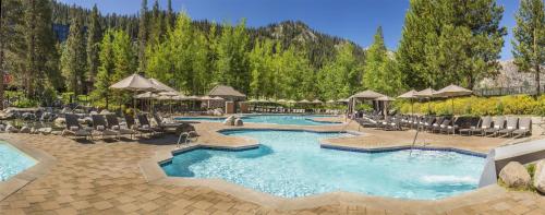 a pool with chairs and umbrellas in a resort at Everline Resort and Spa, Lake Tahoe in Olympic Valley