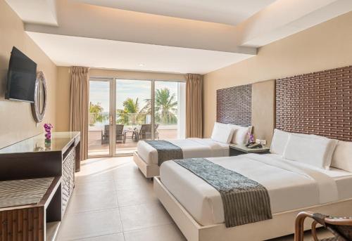two beds in a hotel room with a balcony at The Muse Hotel Boracay in Boracay