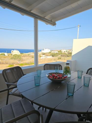 a table and chairs with a bowl of fruit on it at Syros-house in Azolimnos Syros