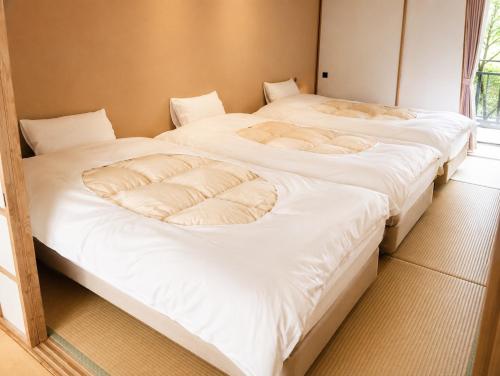 two beds sitting next to each other in a room at Minami Hakone Villa in Kannami