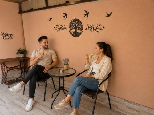 a man and a woman sitting at a table with drinks at Apartment The Garden Ruse, Private Garden & Free Parking in Ruse