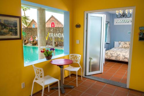 a room with a table and chairs and a bedroom at Veranda Resort Phan Thiết in Tiến Thành
