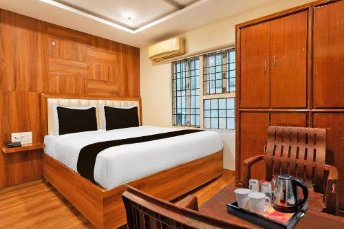 a bedroom with a bed and a table and a desk at Collection O Tennati Park Vizag Beach Formerly B Square Villa in Visakhapatnam